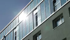 Das Route de Bern 2 Gebäude in Lausanne mit umlaufender Solarfassade der obersten zwei Stockwerke.